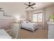 Comfortable bedroom showcasing neutral tones, a queen bed, a ceiling fan, and natural light through the window at 3723 S Pottery Rd, Gold Canyon, AZ 85118