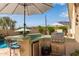 Outdoor kitchen featuring a built-in grill, bar seating, and tile work by the pool, ideal for outdoor dining at 3723 S Pottery Rd, Gold Canyon, AZ 85118