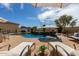 Backyard pool area with lounge chairs, umbrellas, and lush desert landscaping perfect for entertaining at 3723 S Pottery Rd, Gold Canyon, AZ 85118