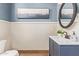 Charming powder room with a blue vanity, decorative mirror, and framed artwork at 3723 S Pottery Rd, Gold Canyon, AZ 85118
