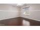 Cozy bedroom with dark laminate floors and a window with blinds, offering a relaxing atmosphere at 4626 N 111Th Ln, Phoenix, AZ 85037