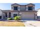 The exterior of the home features a two-car garage, desert landscaping, and neutral paint colors at 4626 N 111Th Ln, Phoenix, AZ 85037