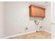 Functional laundry room with overhead cabinets and tile floors at 4626 N 111Th Ln, Phoenix, AZ 85037