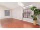 Spacious living room featuring wood floors, neutral walls, window coverings and modern light fixture at 4626 N 111Th Ln, Phoenix, AZ 85037
