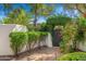 Charming courtyard gate entrance adorned with lush greenery and brick pathway leading into the property at 5838 E Berneil Ln, Paradise Valley, AZ 85253