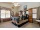 Bright bedroom featuring a ceiling fan and an elegant bed, complemented by matching wooden dressers at 5839 W Ironwood Dr, Glendale, AZ 85302