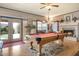 Spacious game room with a pool table, fireplace, and access to the backyard through French doors at 5839 W Ironwood Dr, Glendale, AZ 85302