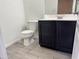 Bathroom features a black vanity with modern fixtures and tile flooring at 720 W Lydia Ln, Phoenix, AZ 85041