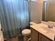Neutral bathroom features a shower with decorative blue curtain, toilet, and a single sink vanity at 720 W Lydia Ln, Phoenix, AZ 85041