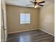 A bright bedroom with a ceiling fan and gray wood floors features a large window at 720 W Lydia Ln, Phoenix, AZ 85041