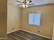 This bright bedroom features a ceiling fan, window with blinds, and gray wood floors at 720 W Lydia Ln, Phoenix, AZ 85041