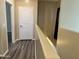 Hallway with gray wood floors and a closed white door leads to other areas of the home at 720 W Lydia Ln, Phoenix, AZ 85041