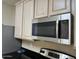 Close-up of the stainless steel microwave and beige cabinets in the bright kitchen at 720 W Lydia Ln, Phoenix, AZ 85041