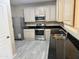 Bright kitchen boasts stainless steel appliances, black countertops, and tile floors at 720 W Lydia Ln, Phoenix, AZ 85041