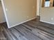 An empty room featuring gray wood floors, neutral colored walls, and white trim throughout at 720 W Lydia Ln, Phoenix, AZ 85041
