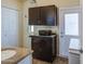 Bathroom featuring dark cabinetry and a utility area with closet at 7750 E Broadway Rd # 535, Mesa, AZ 85208