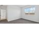 A simple bedroom with neutral walls and flooring, complete with a bright window overlooking the property at 8484 W Clemente Way, Florence, AZ 85132