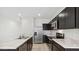 Modern kitchen with stainless steel appliances, marbled countertops, and dark cabinets offering ample storage space at 8484 W Clemente Way, Florence, AZ 85132