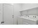 White laundry room features a stacked washer and dryer with a shelf at 8484 W Clemente Way, Florence, AZ 85132