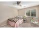 Neutral bedroom featuring a ceiling fan, shuttered windows, and a comfortable bed at 9566 N 83Rd Dr, Peoria, AZ 85345