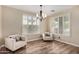Cozy living room with wood floors, two armchairs, and bright shuttered windows at 9566 N 83Rd Dr, Peoria, AZ 85345