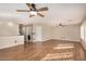 Spacious living room with hardwood floors, two ceiling fans, and neutral colored walls at 9566 N 83Rd Dr, Peoria, AZ 85345
