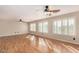 Large room with hardwood floors, light colored walls, plantation shutters, and ceiling fans at 9566 N 83Rd Dr, Peoria, AZ 85345