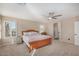 Spacious main bedroom with neutral carpeting, a ceiling fan, a large bed, and bright, shuttered windows at 9566 N 83Rd Dr, Peoria, AZ 85345