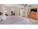 Spacious main bedroom featuring a ceiling fan, shuttered windows, and an en suite bathroom and walk-in closet at 9566 N 83Rd Dr, Peoria, AZ 85345