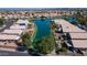 Aerial view of community homes along a lake with lush landscaping, mature trees and solar panels on several roofs at 10387 W Runion Dr, Peoria, AZ 85382