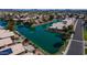 Aerial view of community homes along the lake with fountain, green landscaping, mature trees and covered patios at 10387 W Runion Dr, Peoria, AZ 85382