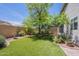Lush backyard featuring artificial grass, mature shade trees, and desert landscaping at 10387 W Runion Dr, Peoria, AZ 85382