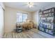 Well-lit secondary bedroom with desk and shelving unit, wood-look tile floors, and natural light at 10387 W Runion Dr, Peoria, AZ 85382