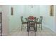 Dining area with decorative wrought-iron table and chairs set, chandelier lighting, and tiled flooring at 10387 W Runion Dr, Peoria, AZ 85382