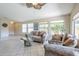 Spacious living room featuring tile floors, large windows, and comfortable seating at 10387 W Runion Dr, Peoria, AZ 85382