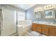 Bright main bathroom with double sinks, soaking tub, and shower with glass door, updated lighting at 10387 W Runion Dr, Peoria, AZ 85382