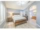 Comfortable main bedroom with a modern wooden bed frame and ensuite bathroom with a soaking tub at 10387 W Runion Dr, Peoria, AZ 85382