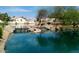 Serene community pond with rock feature and mature trees in a residential setting at 10387 W Runion Dr, Peoria, AZ 85382