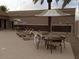 Relaxing pool area featuring lounge chairs, tables with umbrellas, and well-maintained concrete at 10387 W Runion Dr, Peoria, AZ 85382