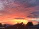 Vibrant sunset paints the sky in fiery hues, creating a picturesque backdrop for this beautiful community at 10387 W Runion Dr, Peoria, AZ 85382