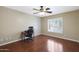 Bright bedroom with wood floors, a ceiling fan, and natural light streaming through shuttered windows at 10504 E Diamond Ave, Mesa, AZ 85208