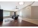 Bright living room with dark wood flooring, modern ceiling fan, and plantation shutters at 10504 E Diamond Ave, Mesa, AZ 85208