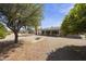 Spacious backyard featuring desert landscaping, mature trees, and an enclosed patio at 1056 S 81St St, Mesa, AZ 85208