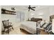 Bright bedroom featuring a ceiling fan, natural light, a storage shelf, and neutral walls at 1056 S 81St St, Mesa, AZ 85208