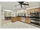 Well-lit kitchen showcasing wooden cabinetry, black countertops, and stainless steel appliances at 1056 S 81St St, Mesa, AZ 85208