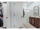 Bright bathroom with a glass door shower and brown cabinets with granite vanity at 14419 W El Cortez Pl, Surprise, AZ 85387
