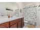 Well-lit bathroom with a single sink vanity, a shower, and a toilet at 14419 W El Cortez Pl, Surprise, AZ 85387