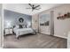 Comfortable bedroom with neutral paint, carpet flooring, a ceiling fan, and a large window providing natural light at 14419 W El Cortez Pl, Surprise, AZ 85387
