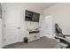 Cozy bedroom features a large TV, modern cabinet, and multiple access doors at 14419 W El Cortez Pl, Surprise, AZ 85387