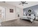 Bedroom with neutral walls, carpet, ensuite bathroom, and ceiling fan at 14419 W El Cortez Pl, Surprise, AZ 85387